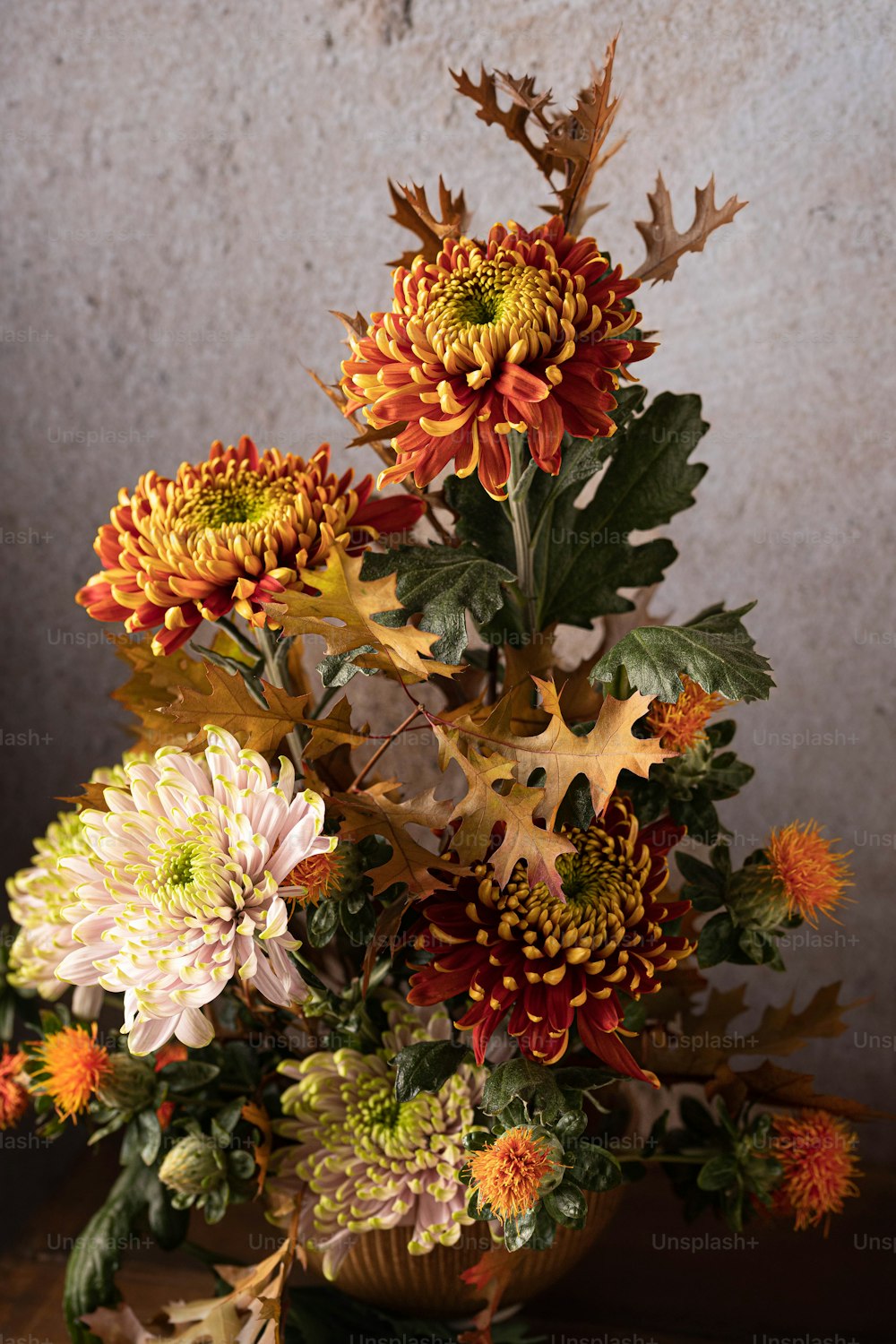 eine Vase gefüllt mit vielen Blumen auf einem Tisch