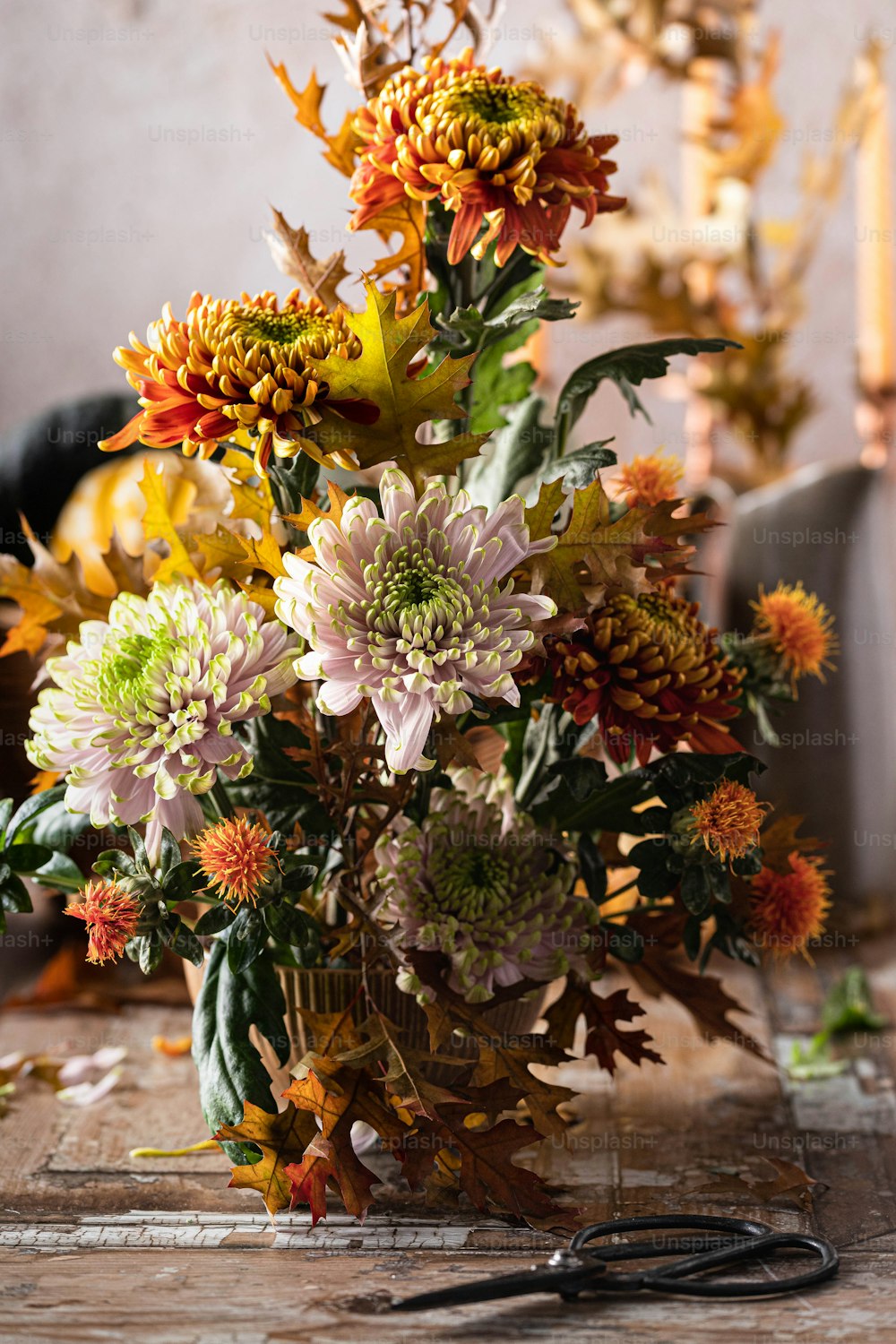 a vase filled with lots of flowers next to a pair of scissors