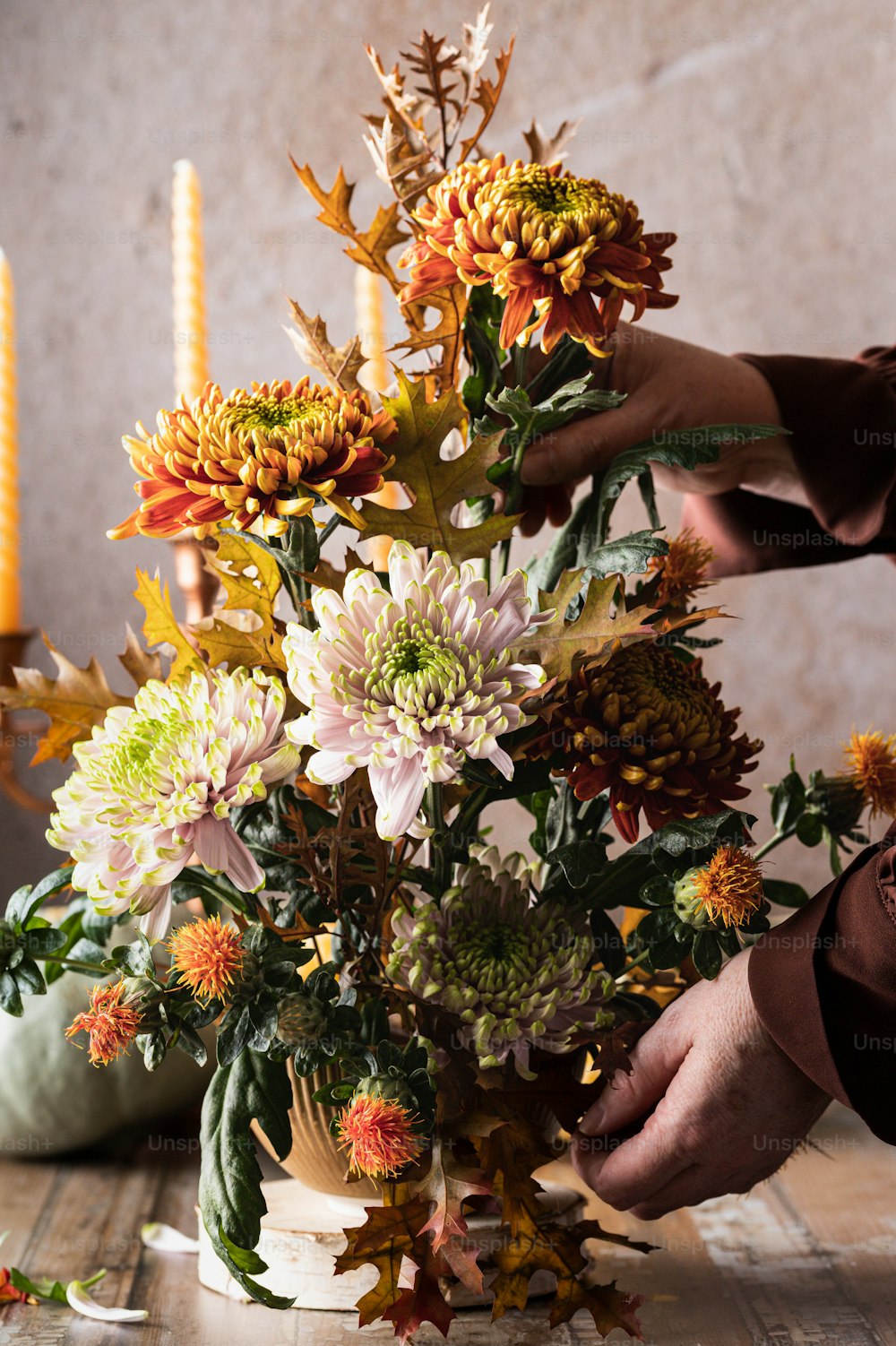 una persona che dispone i fiori in un vaso su un tavolo