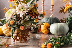 eine Vase gefüllt mit vielen Blumen, die auf einem Holztisch sitzt