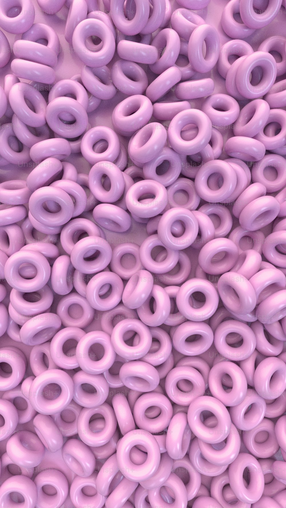 a bunch of pink donuts are stacked on top of each other