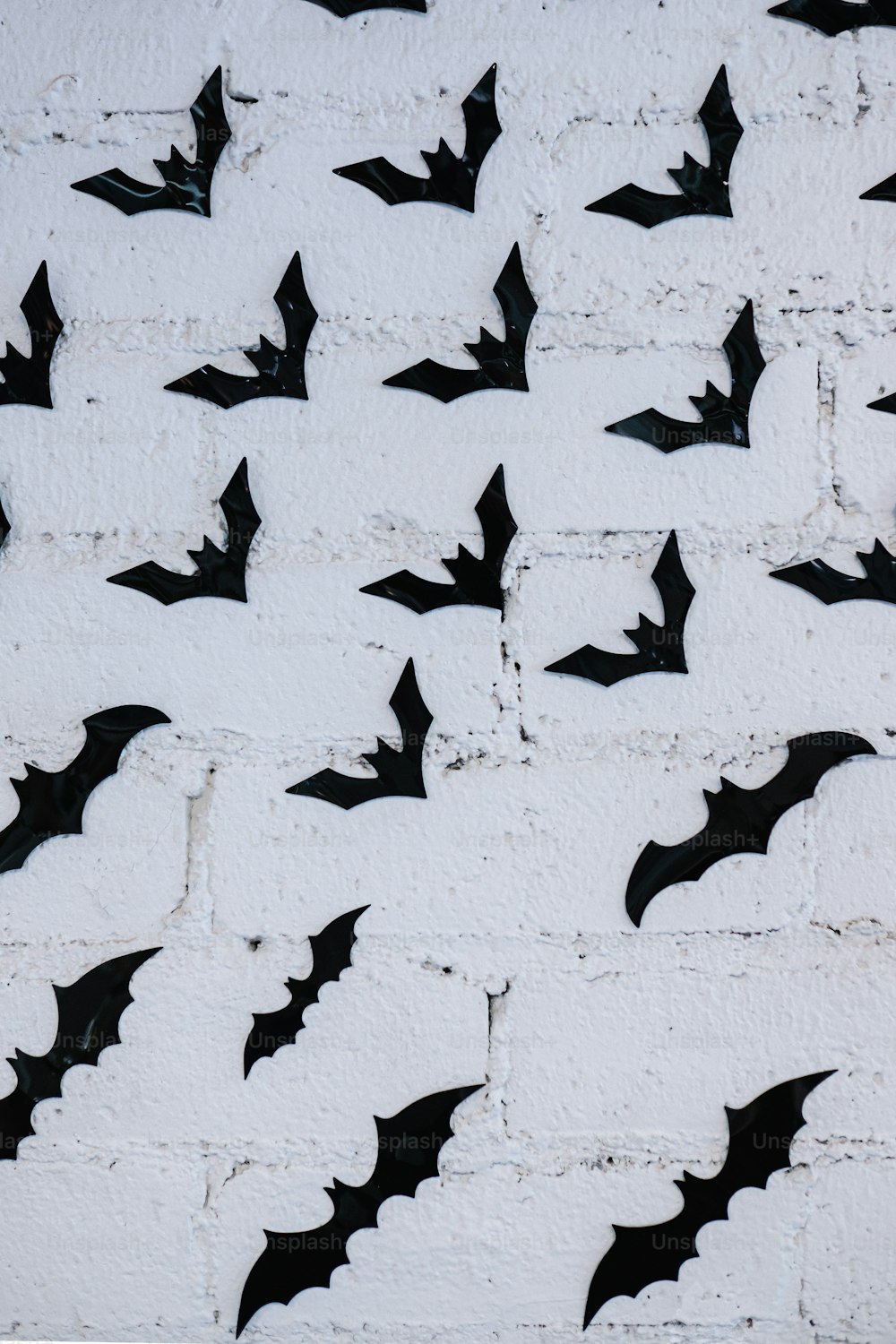 a group of bats on a white brick wall
