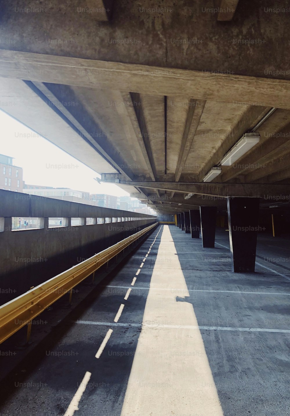 a train traveling under a bridge next to tall buildings