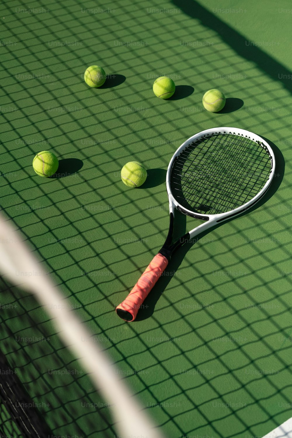 una raqueta de tenis y pelotas en una cancha de tenis