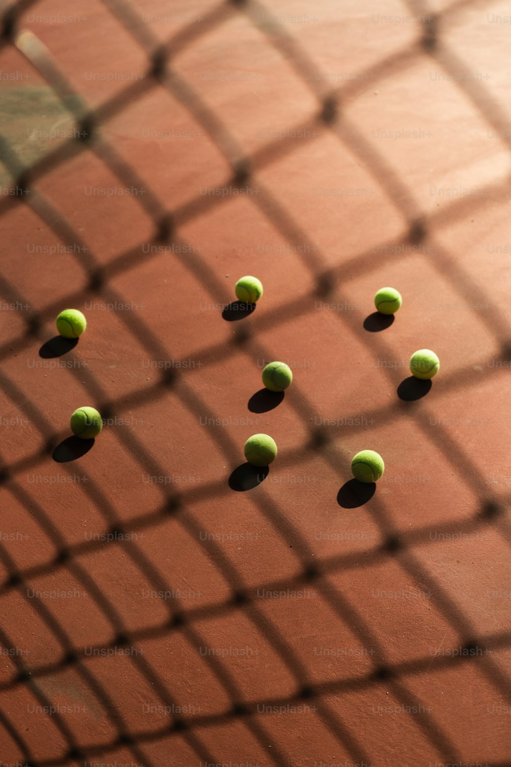 Un grupo de pelotas de tenis sentadas encima de una cancha de tenis