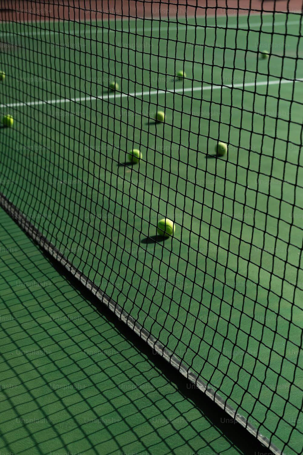 uma quadra de tênis com várias bolas de tênis