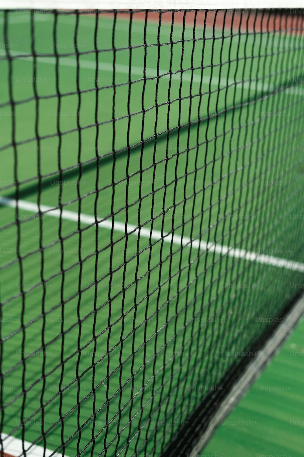 Eine Nahaufnahme eines Tennisnetzes auf einem Tennisplatz