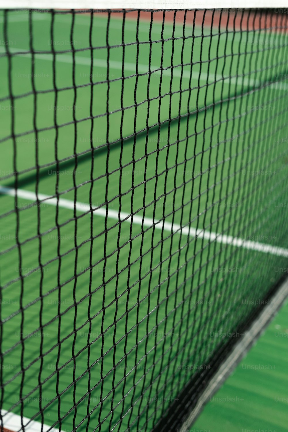 Un primer plano de una red de tenis en una cancha de tenis