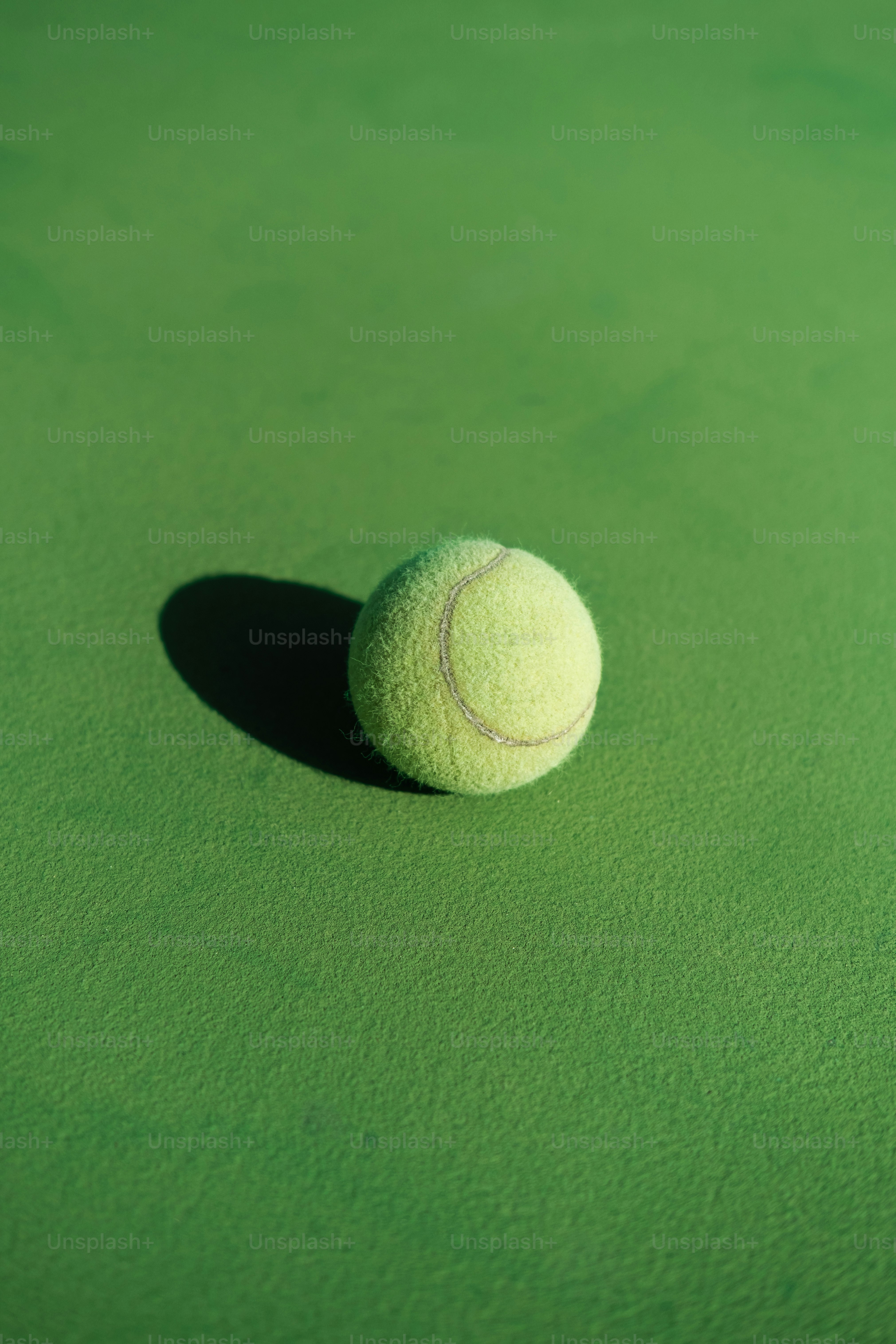 a tennis ball sitting on top of a green court