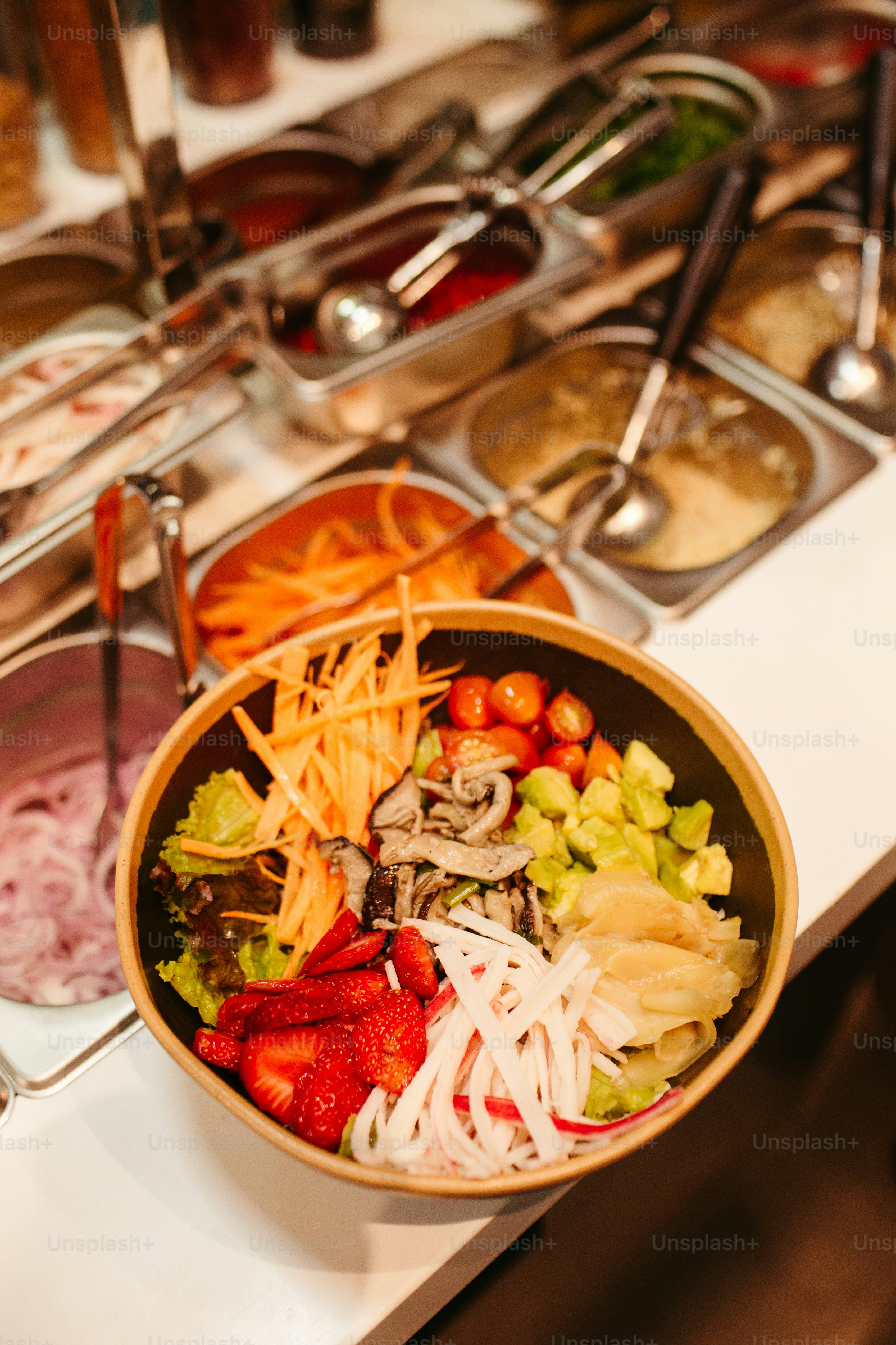 a bowl of salad on a table with other food items