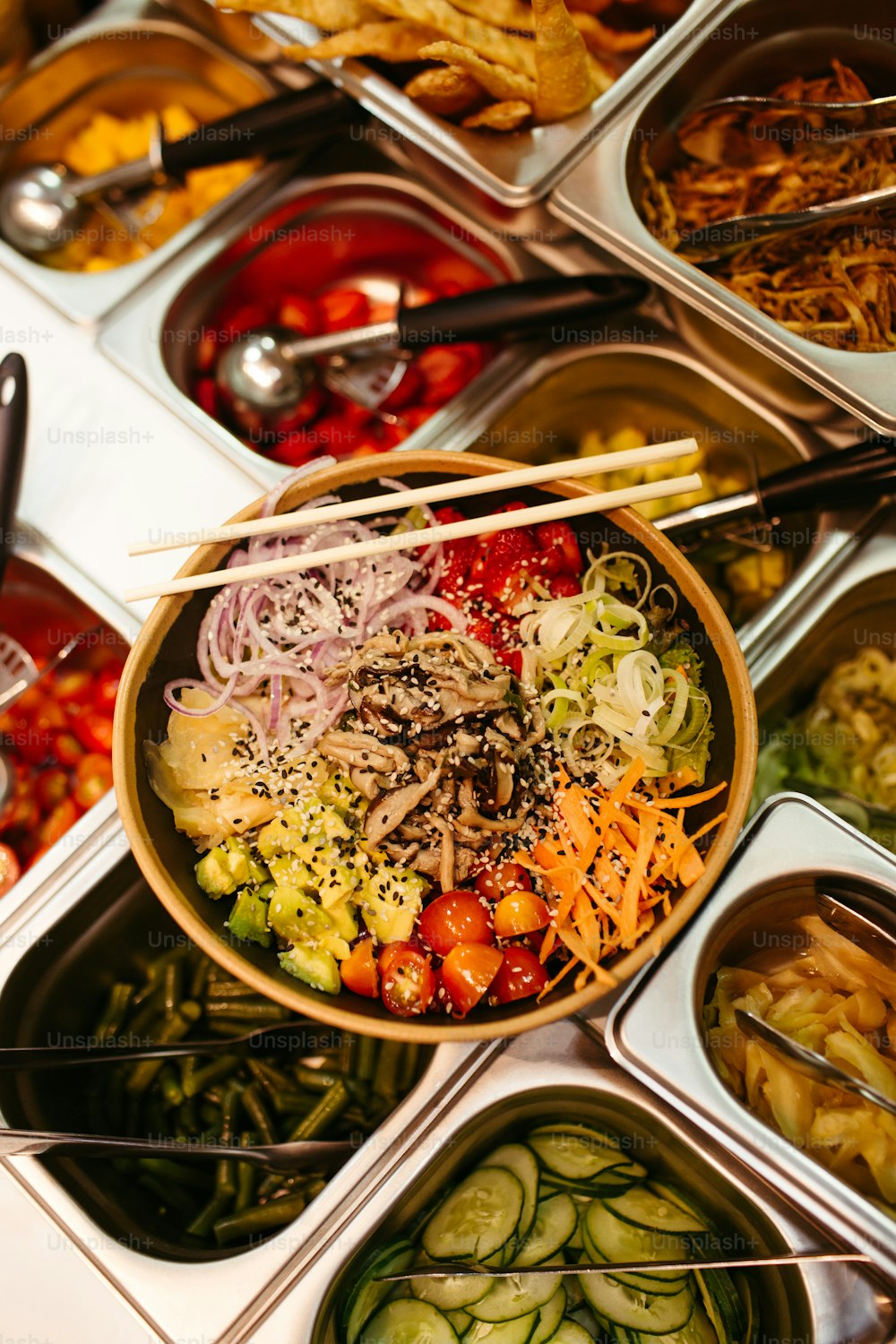 a bowl of food with chopsticks on top of it