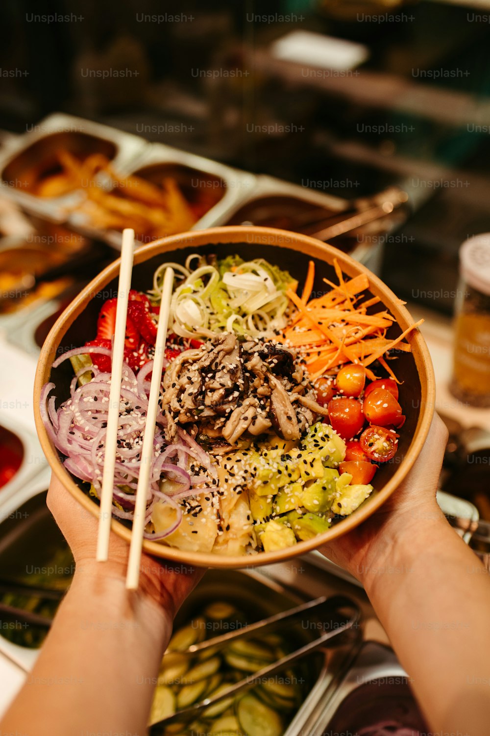 a person holding a bowl of food with chopsticks