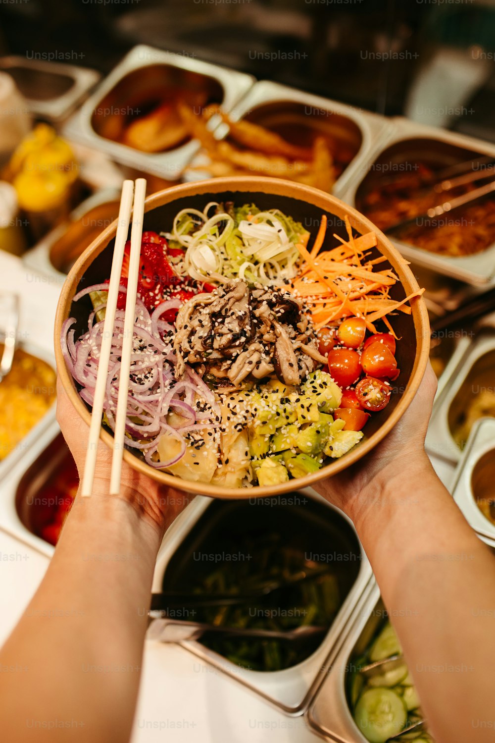 a person holding a bowl of food with chopsticks