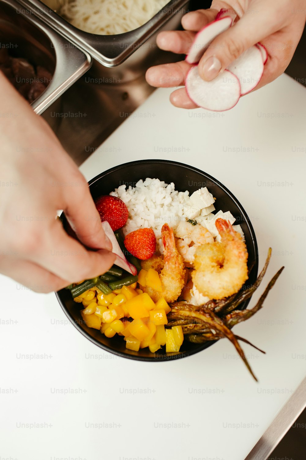 a bowl of food with shrimp, rice, and strawberries