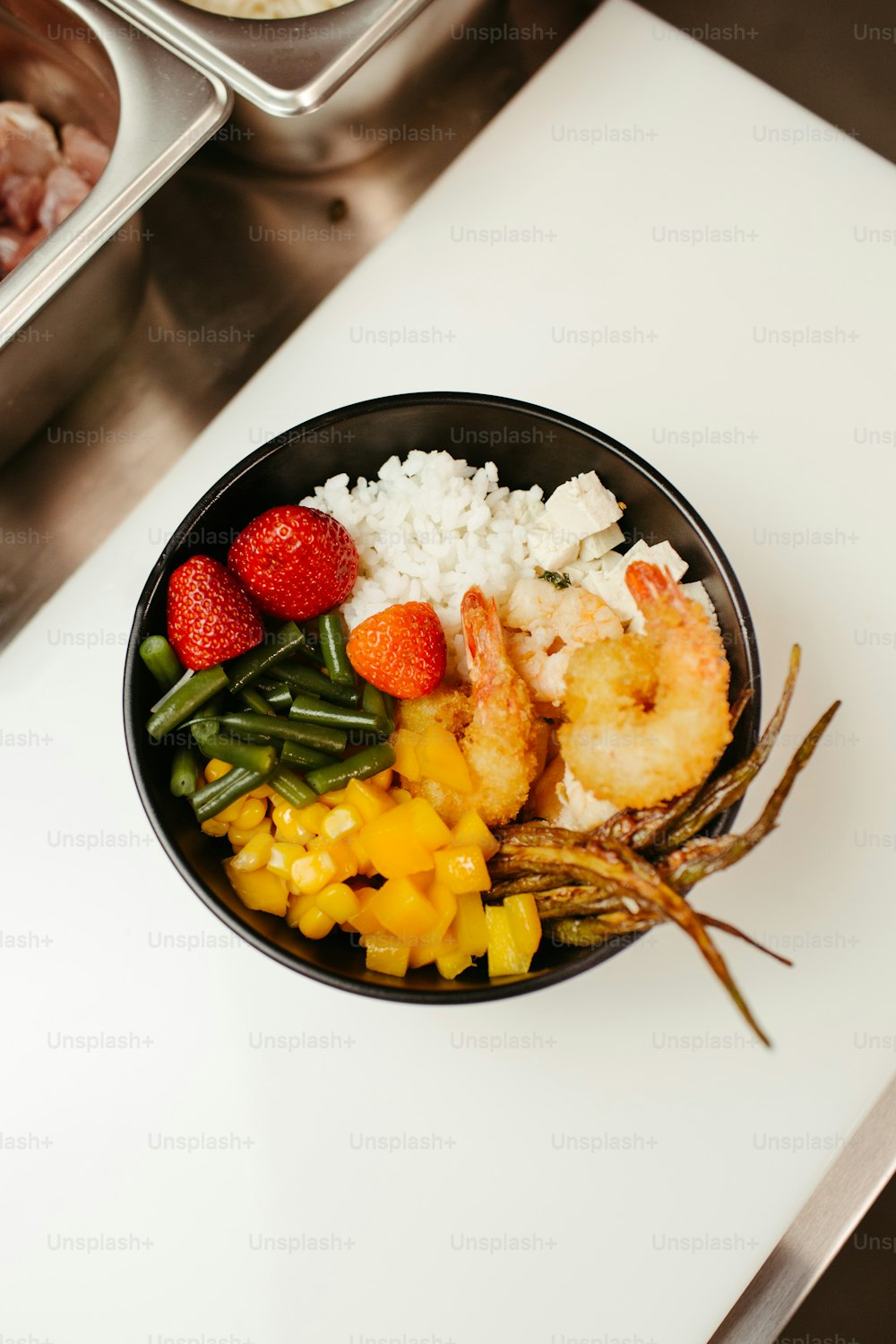 eine Schüssel mit Essen mit Garnelen, Reis und Obst