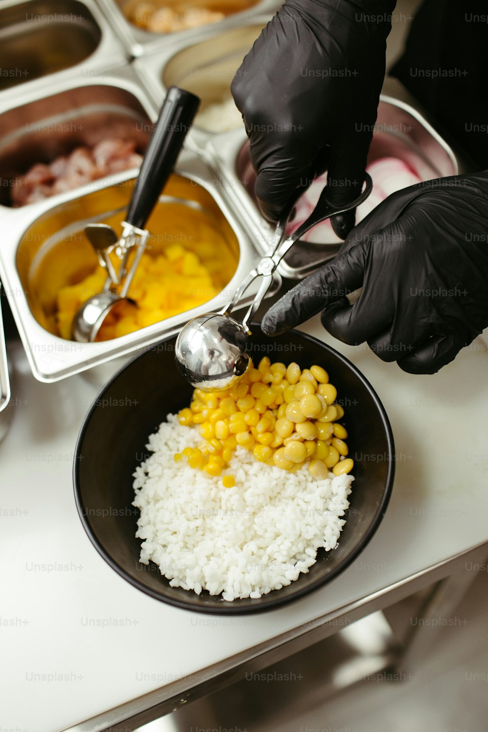 a person in black gloves and gloves preparing food