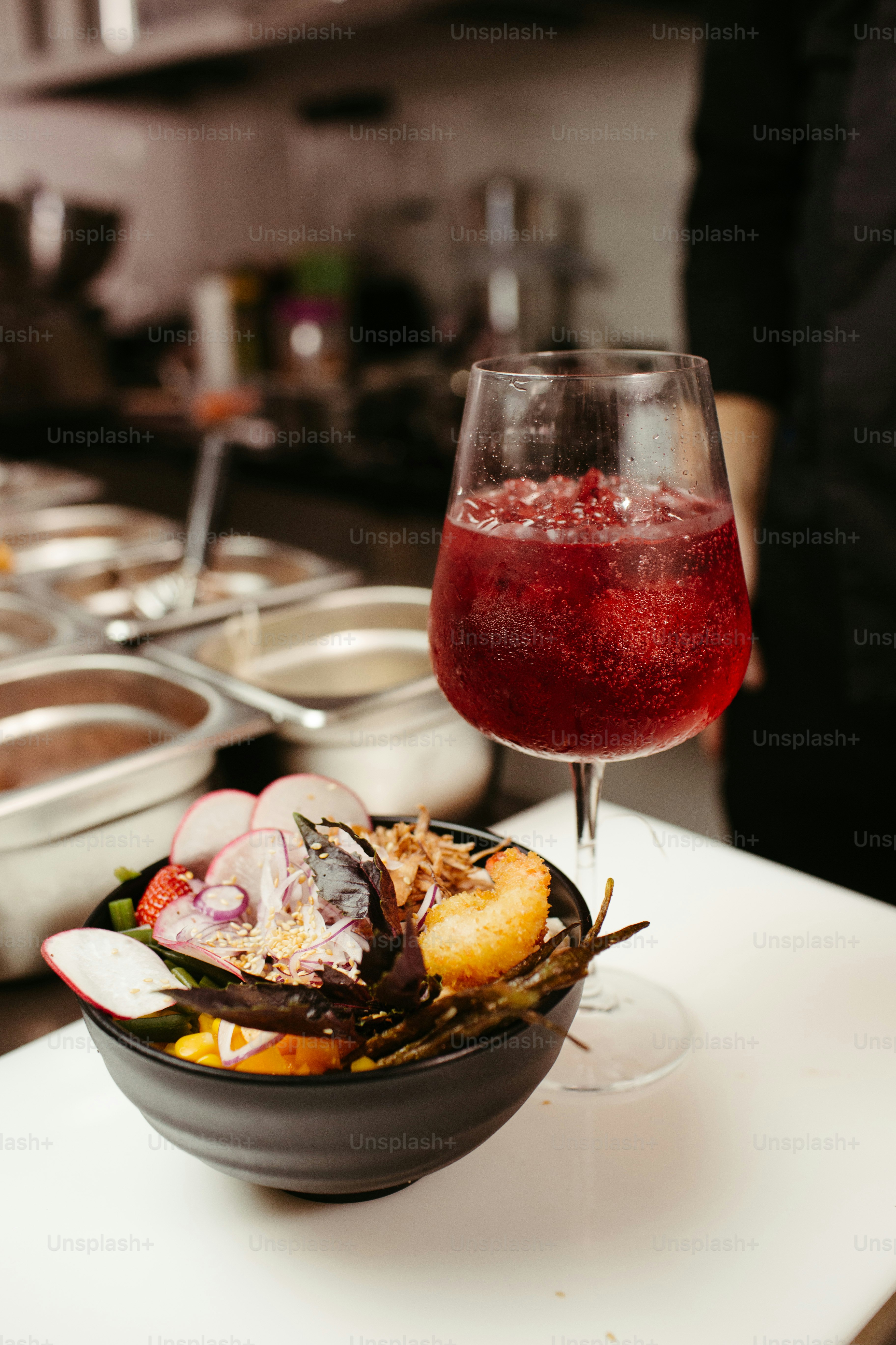 un tazón de comida y una copa de vino sobre una mesa