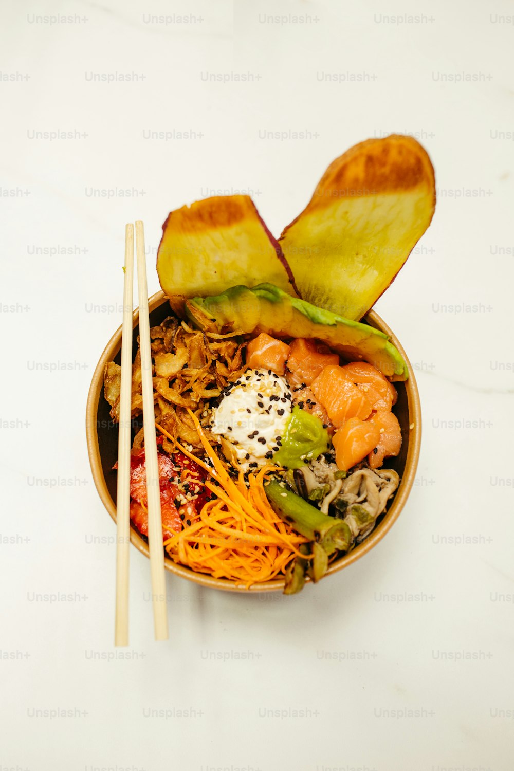 a bowl of food with chopsticks on the side