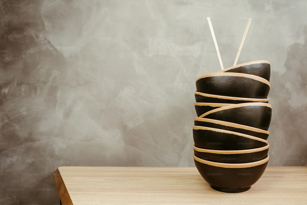 a black vase with sticks sticking out of it