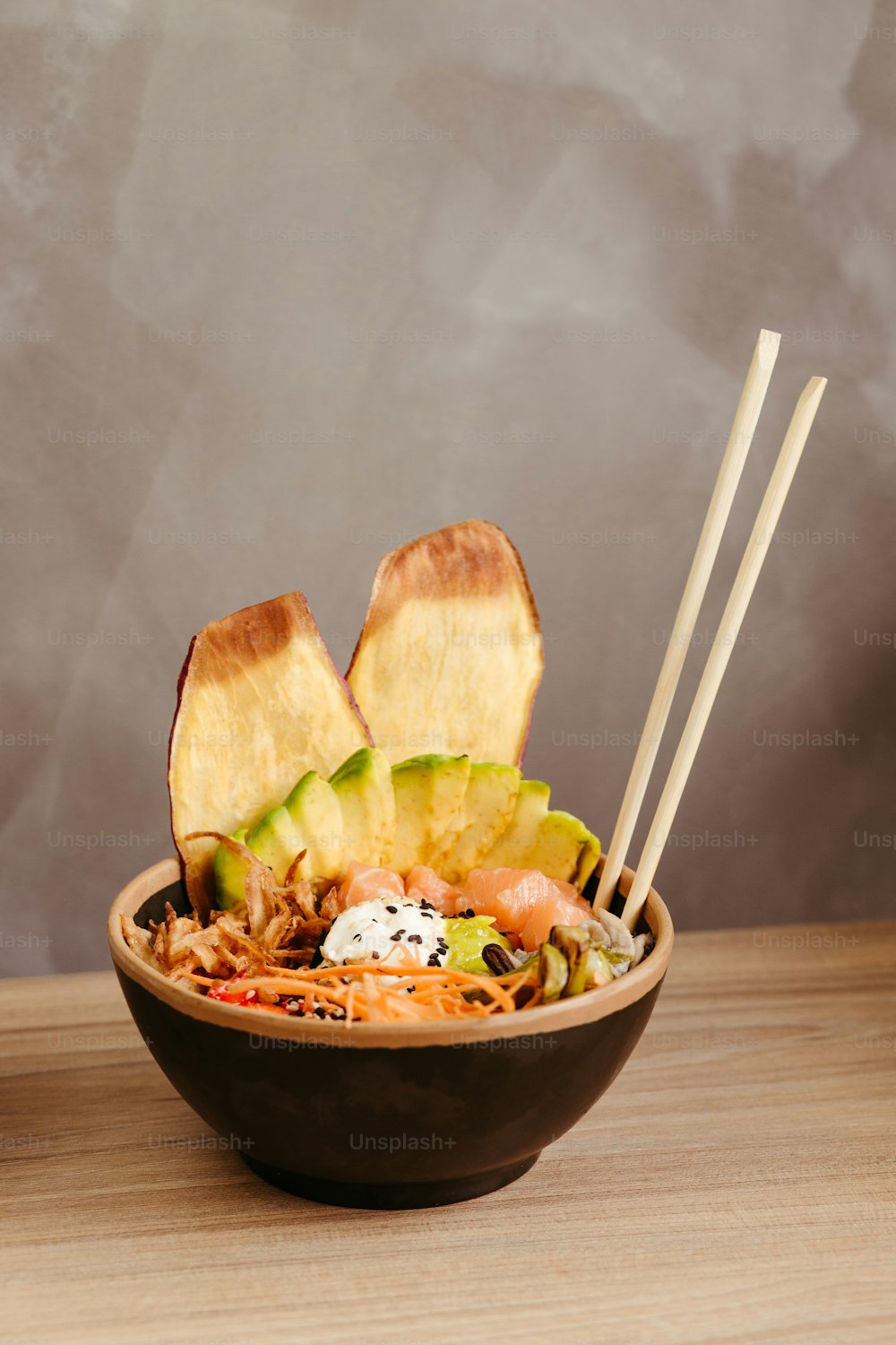 a bowl of food with chopsticks in it