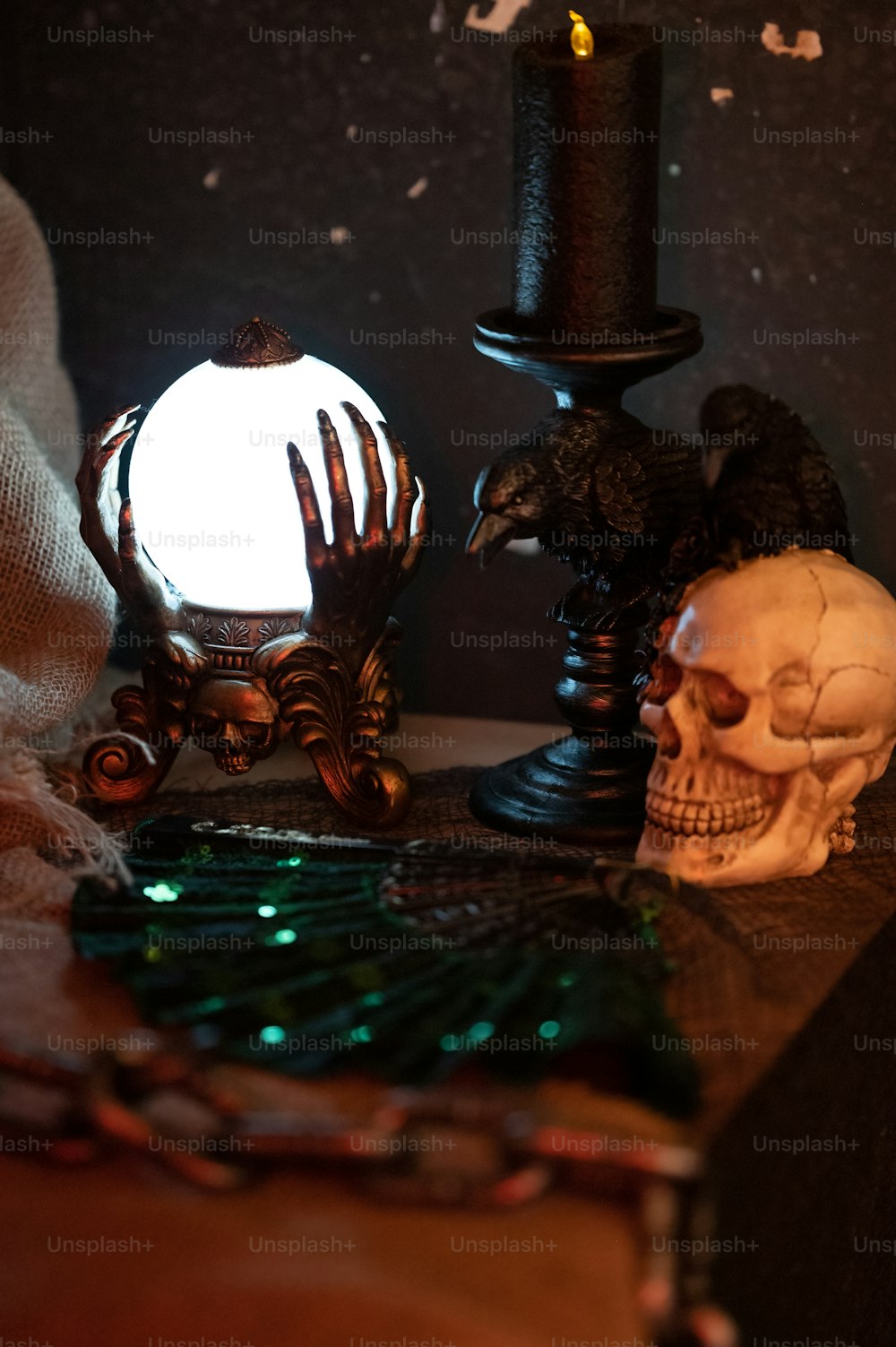 a table topped with a skull and a candle