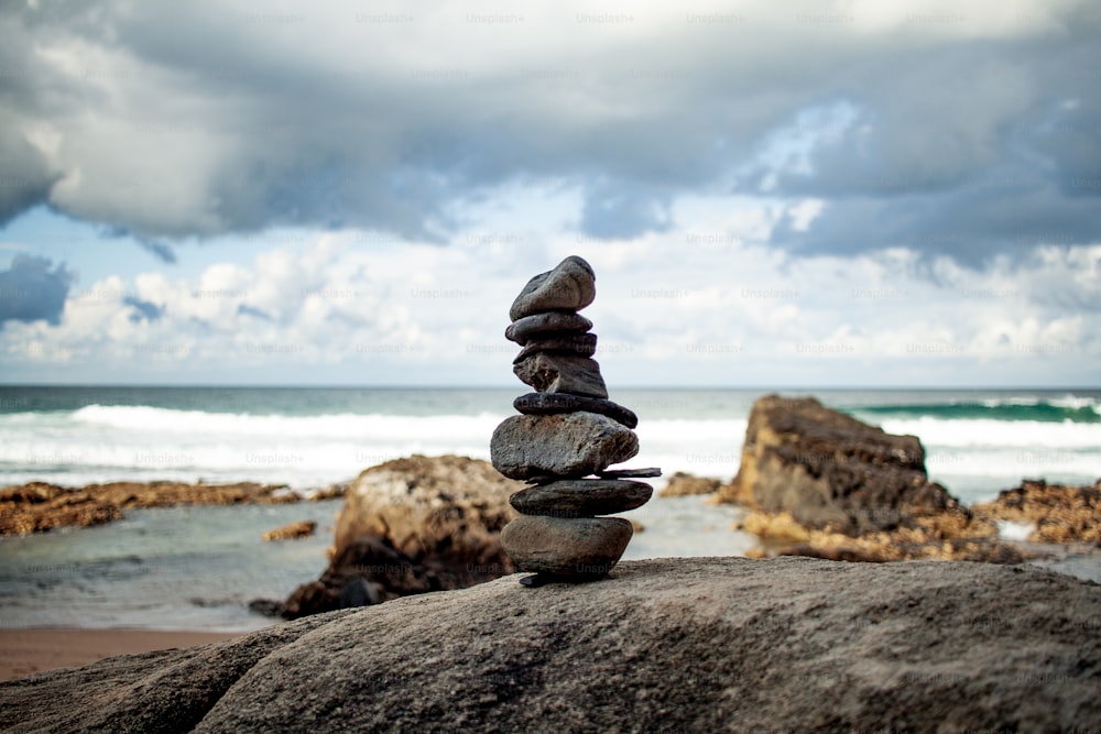 uma pilha de rochas sentada em cima de uma praia