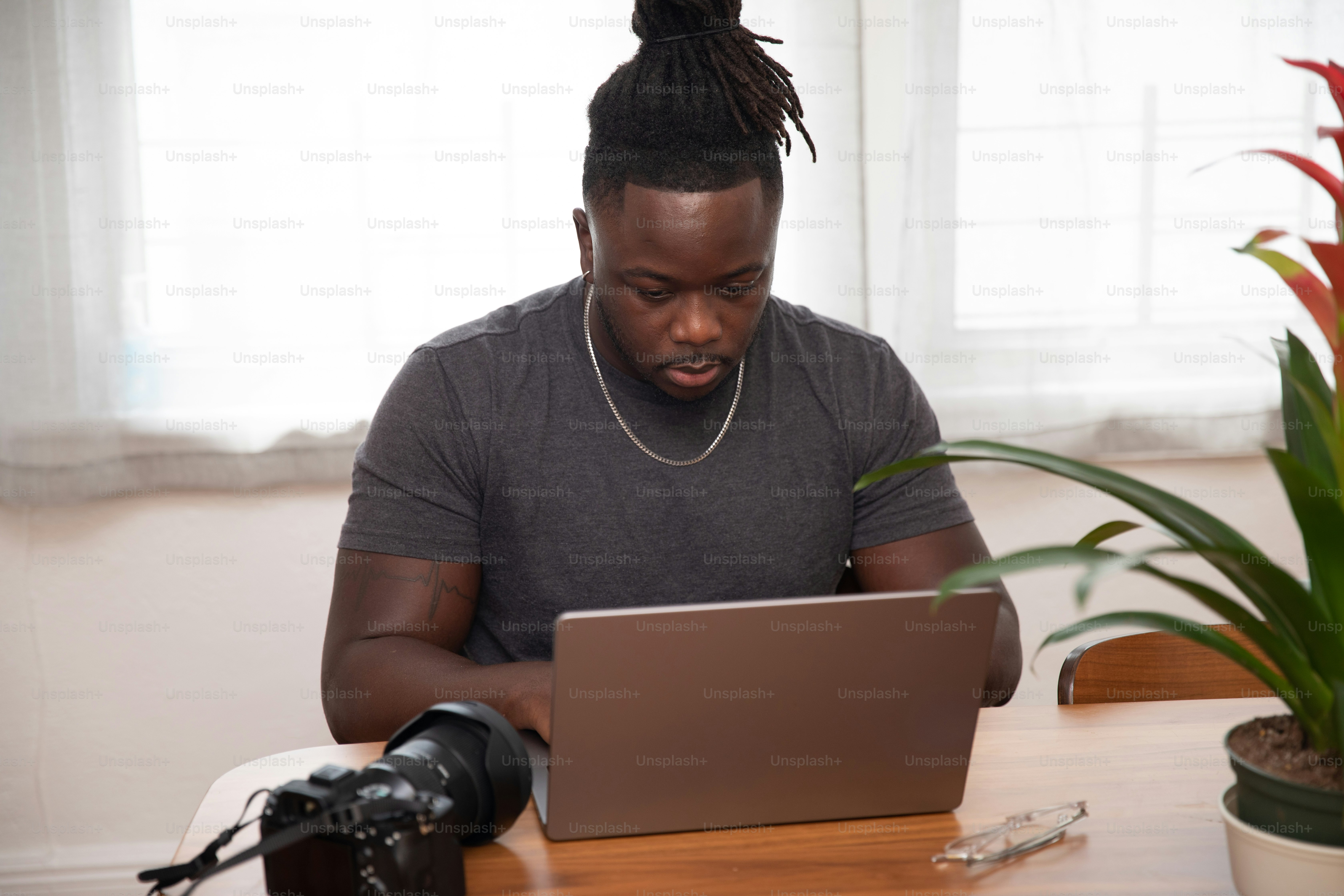 Ein Mann, der mit einem Laptop an einem Tisch sitzt