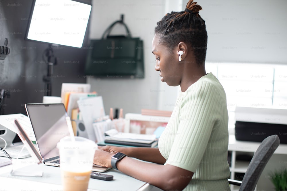 une femme assise à un bureau utilisant un ordinateur portable