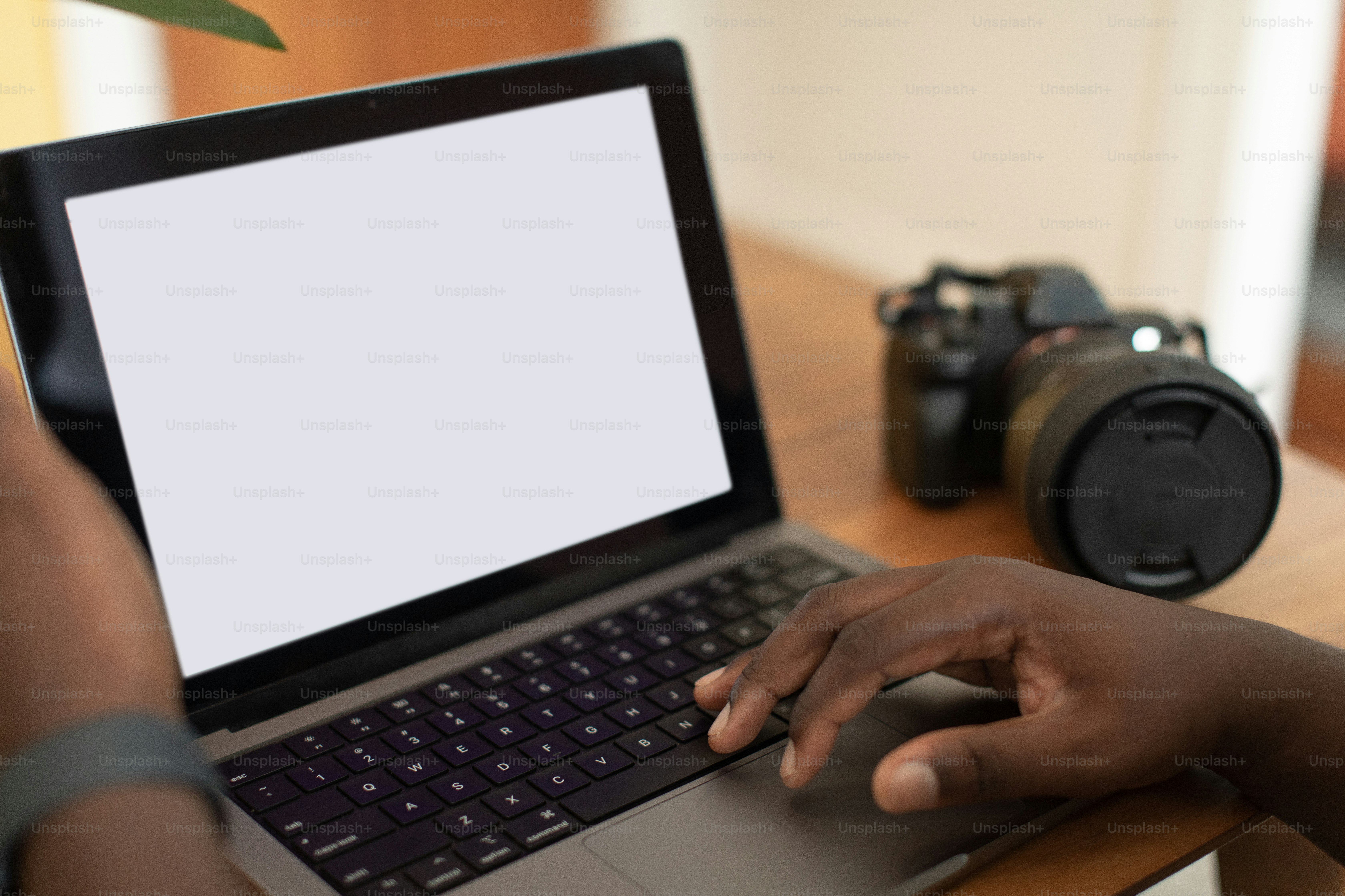 eine Person, die einen Laptop auf einem Holztisch benutzt