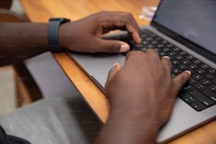 a person using a laptop computer on a wooden table
