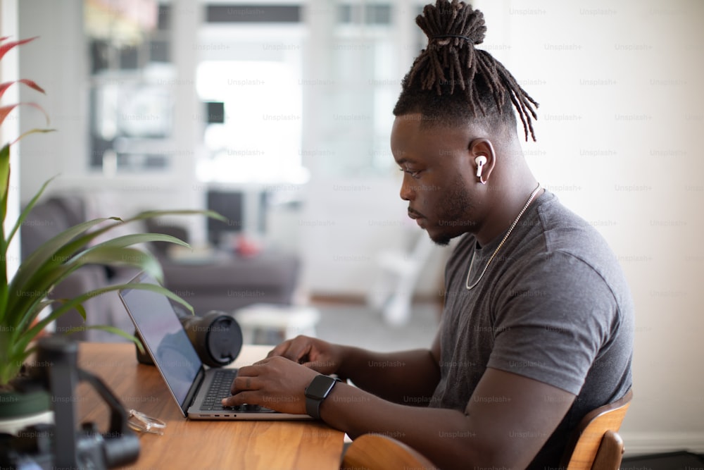 a man sitting at a table using a laptop computer