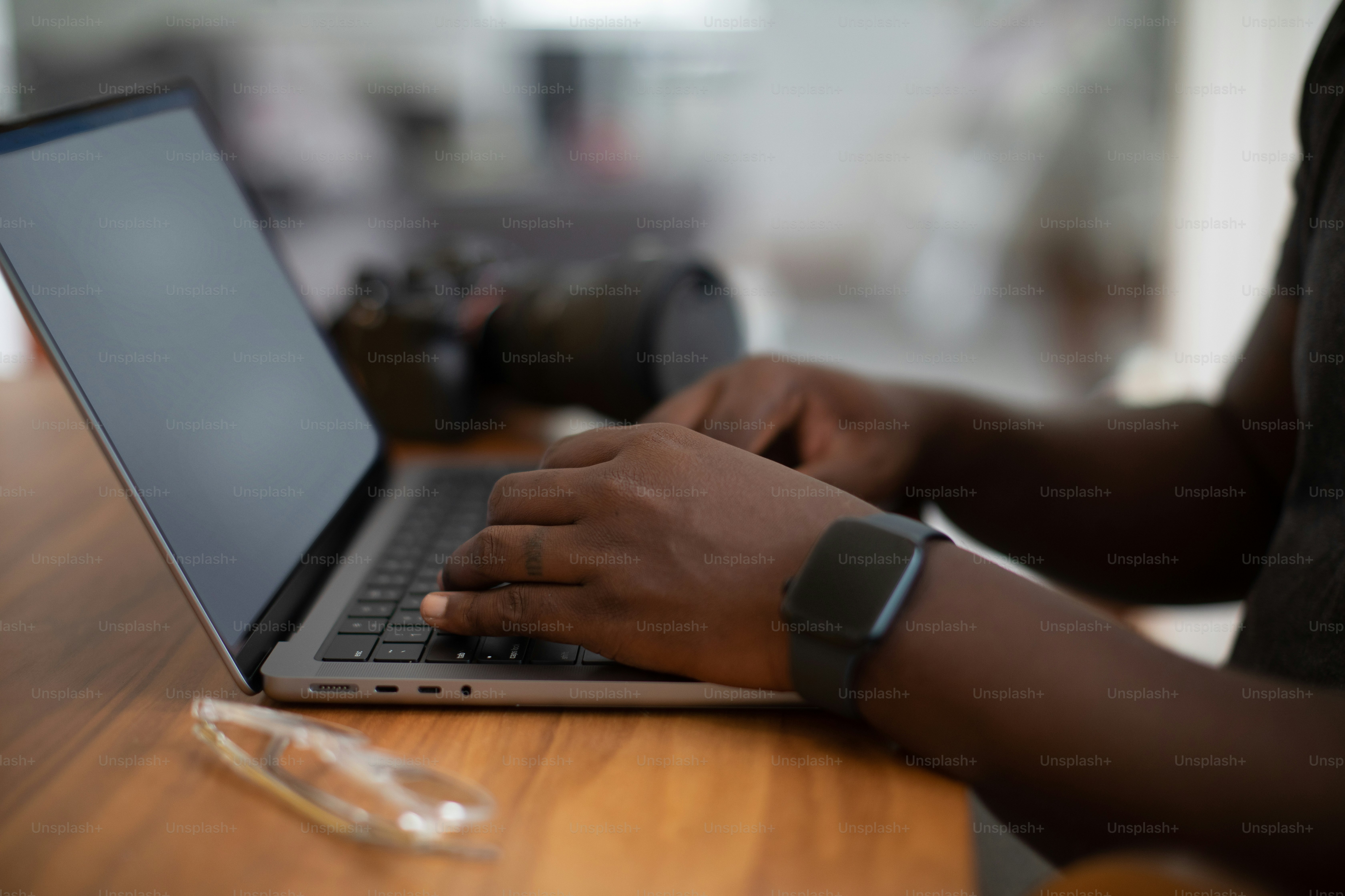 eine Person, die einen Laptop auf einem Holztisch benutzt