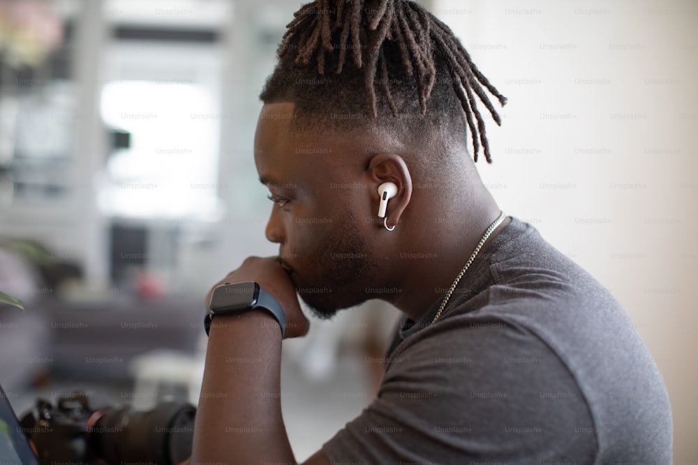 a man with dreadlocks looking at a laptop