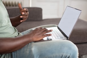 a man sitting on a couch using a laptop computer