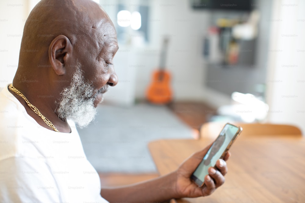 Un hombre sentado en una mesa mirando un teléfono celular