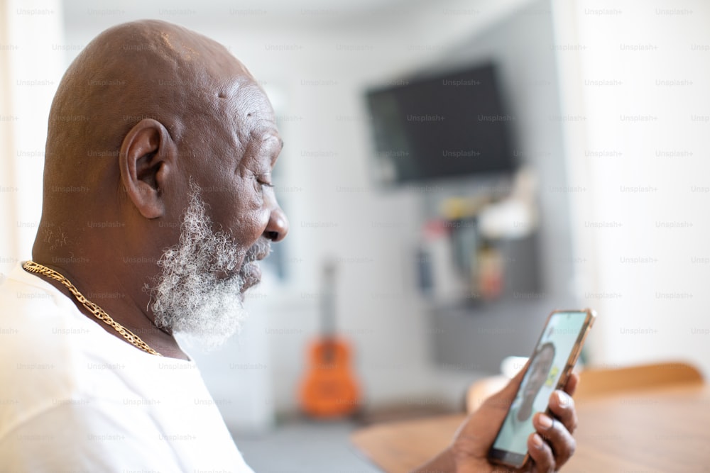 a man with a white beard holding a cell phone