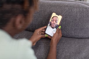 a woman sitting on a couch holding a cell phone