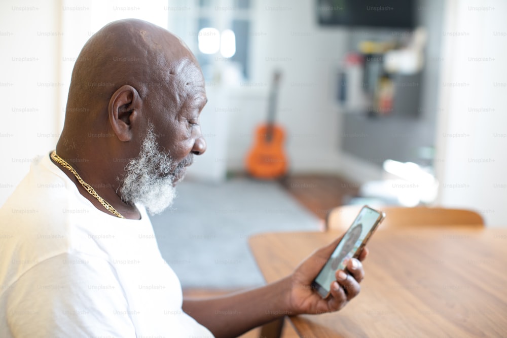 a man sitting at a table looking at a cell phone