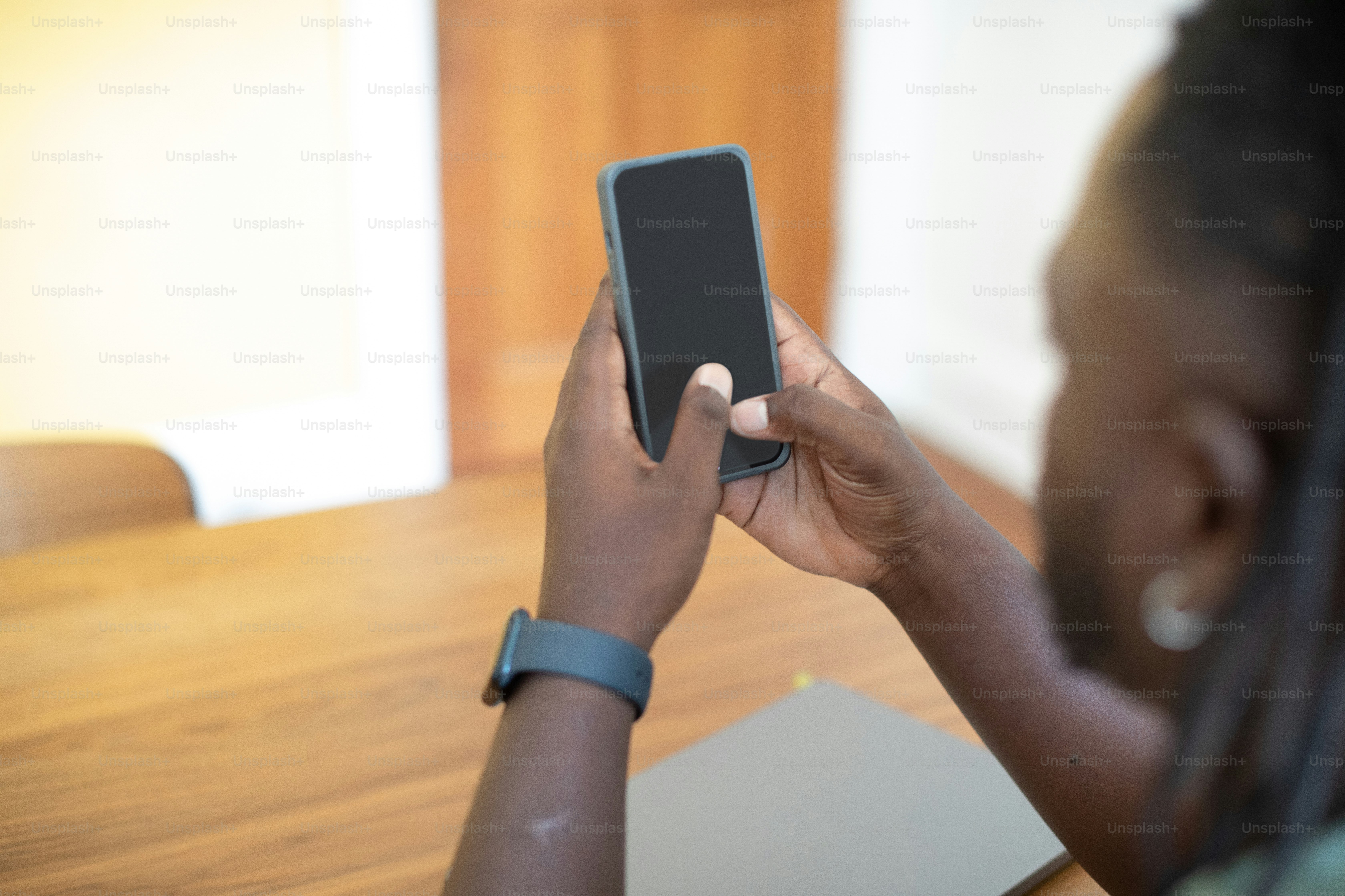 una donna seduta a un tavolo usando un telefono cellulare