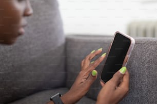 una donna che usa un telefono cellulare mentre è seduta su un divano