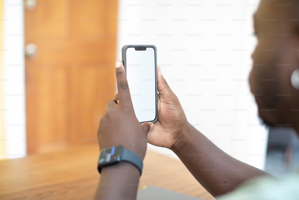 eine Person, die ein Handy vor ihr Gesicht hält