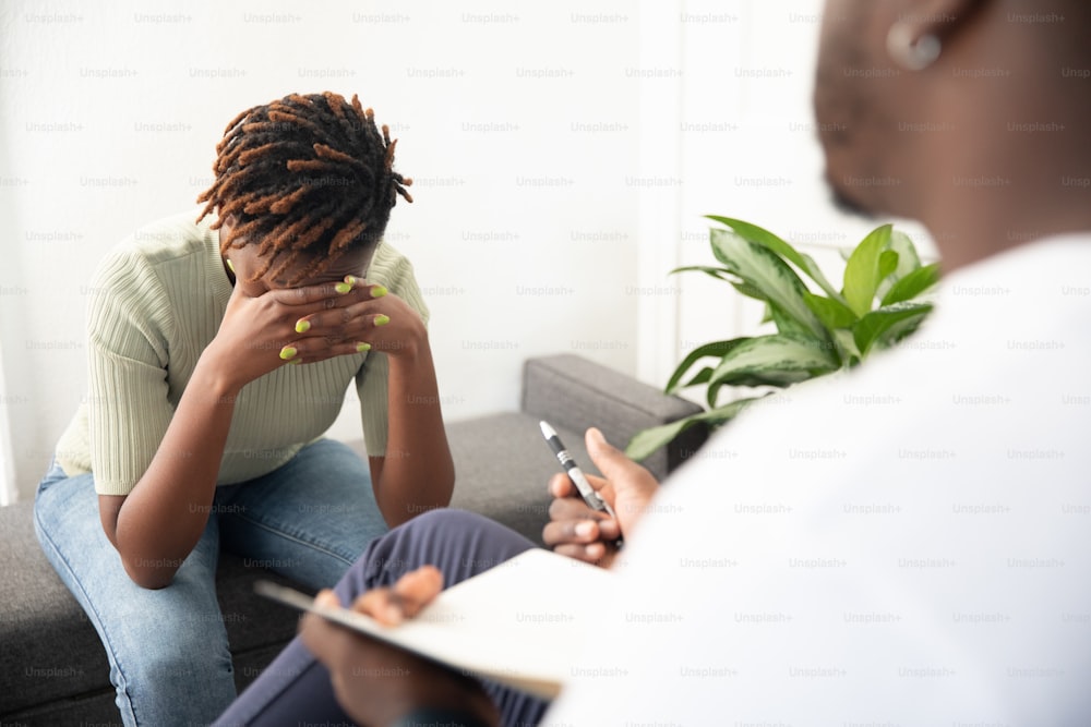 a woman sitting on a couch talking to another woman