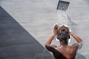 Un uomo si sta lavando i capelli sotto la doccia