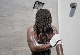 Un uomo con i dreadlocks in piedi in una doccia