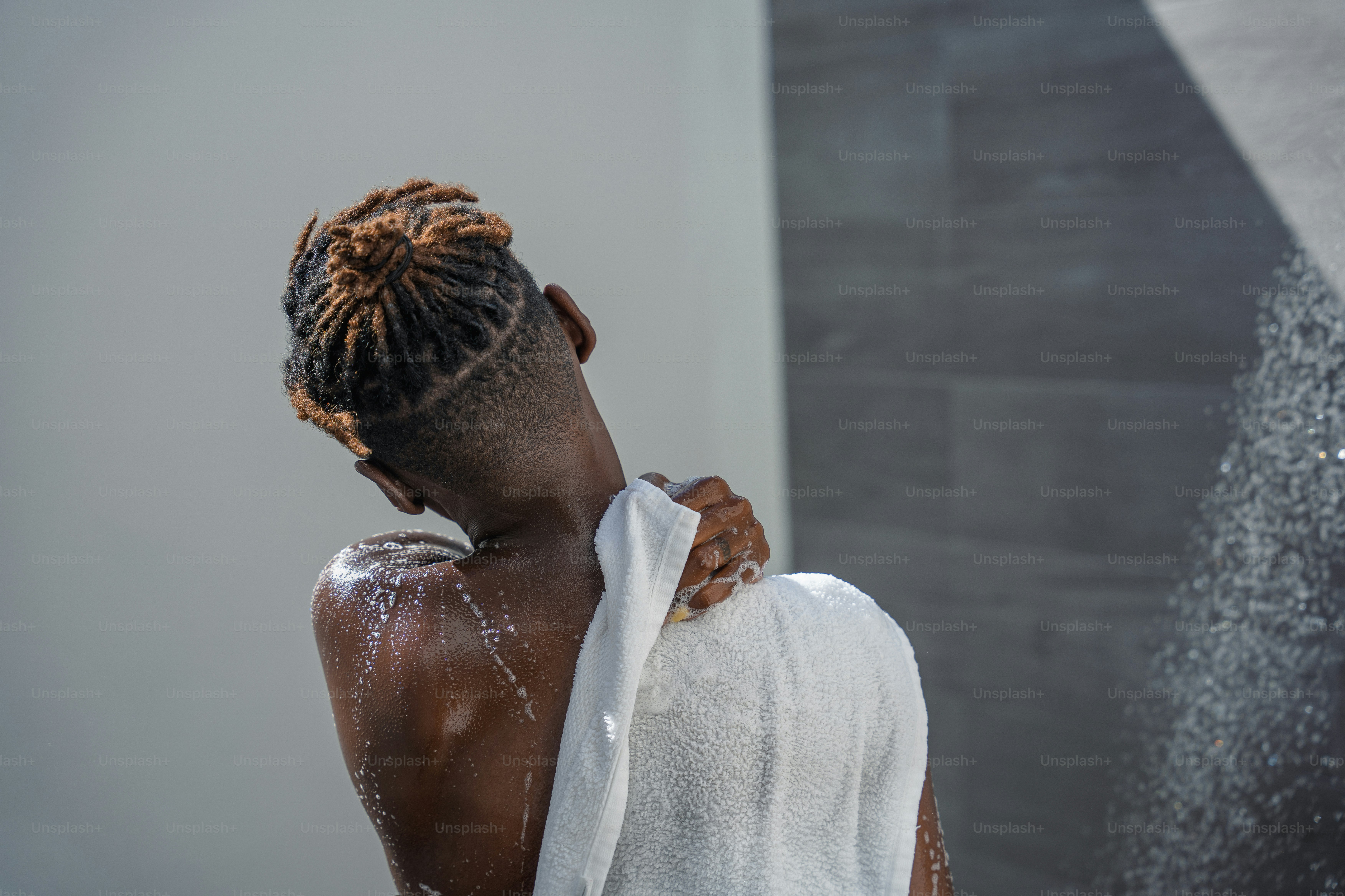 A woman with dreadlocks standing in a shower photo Man shower Image