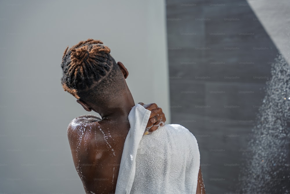 a woman with dreadlocks standing in front of a shower