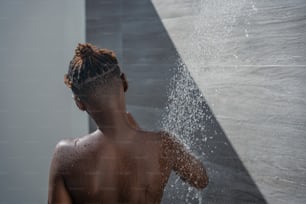 eine Person, die in einer Dusche steht und aus der Wasser austritt