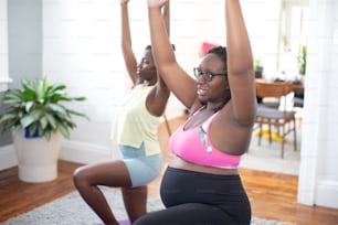two women doing yoga in a living room
