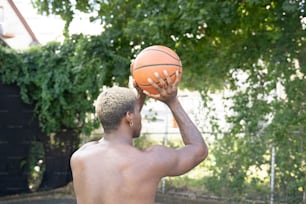Un homme tenant un ballon de basket contre son visage
