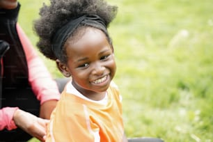 a little girl sitting in a chair smiling